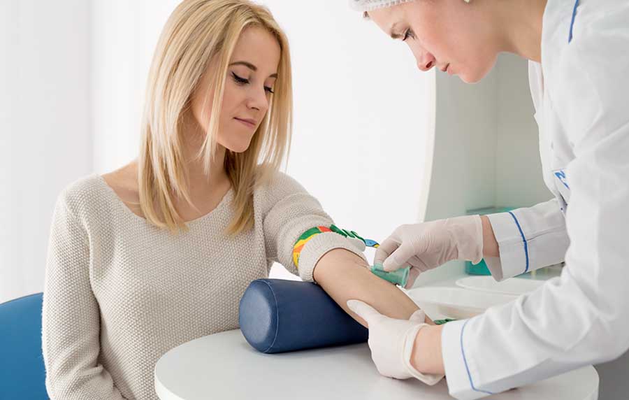 woman getting her blood drawn by a doctor